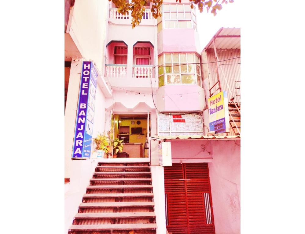 a building with stairs leading up to a door at Hotel Banjara, Pachmarhi in Pachmarhī