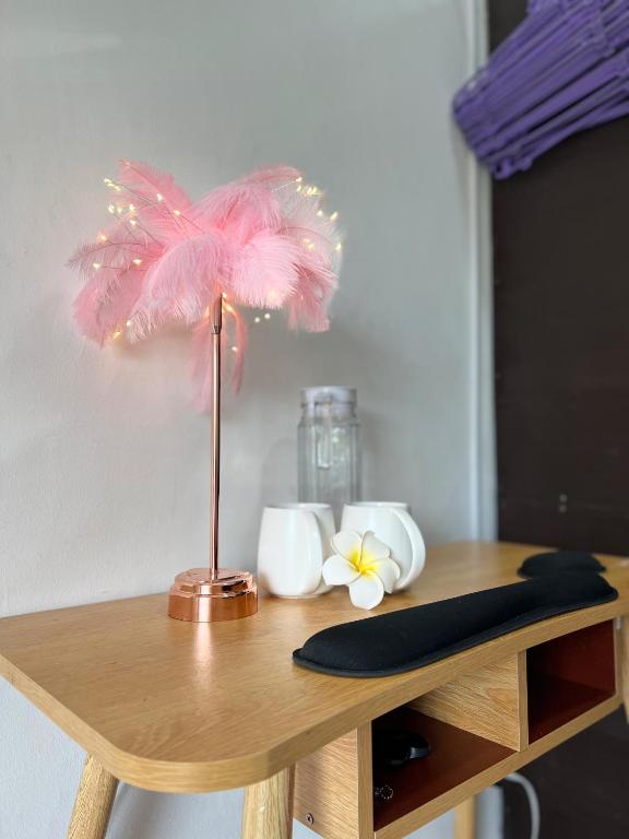 una lampada rosa in piuma su un tavolo di legno di GCASH - Taal cozy private homestay with PRIVATE attached bathroom in General Trias - Pink Room a General Trias