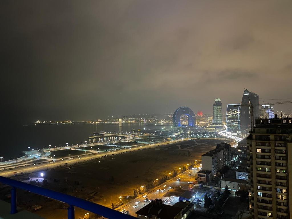 a city at night with a beach and buildings at Meqafun Sea View apartment in Baku