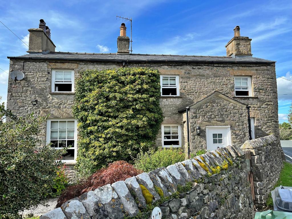 an old stone house with a ivy growing on it at Finest Retreats - Ivy Cottage in Casterton