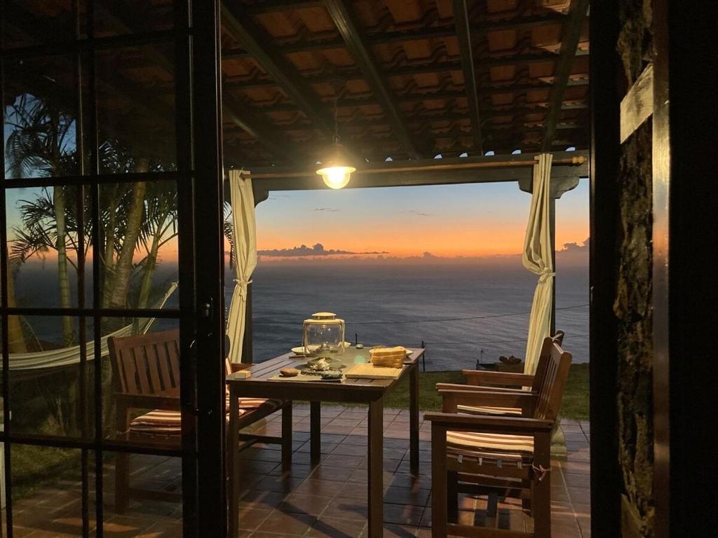 una mesa y sillas en un patio con vistas al océano en Casa Garcia-Mar en Los Quemados