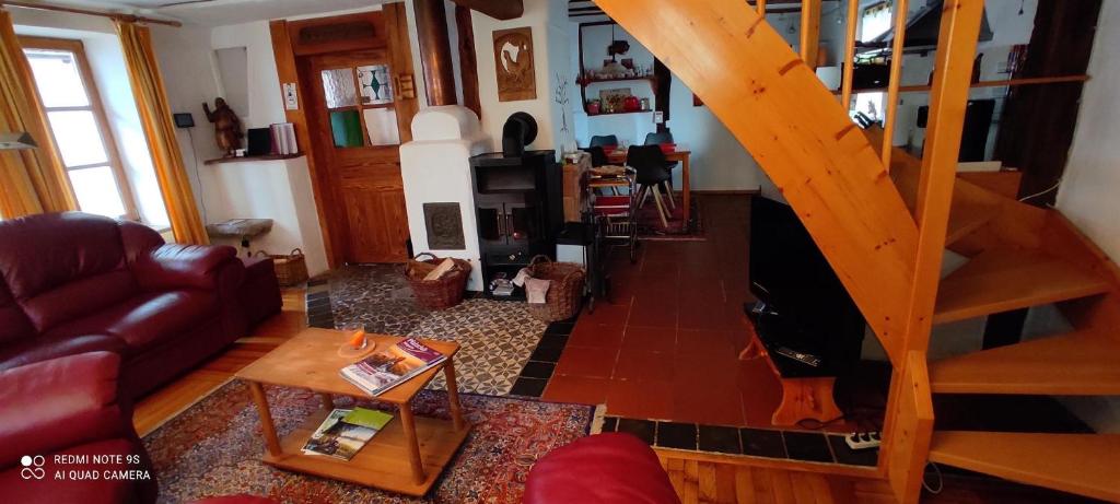 ein Wohnzimmer mit einem Sofa und einer Treppe in der Unterkunft Ferienhaus Pfalzklause in Billigheim-Ingenheim