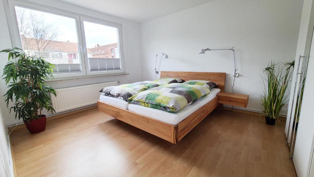 - une chambre avec un lit et deux plantes en pot dans l'établissement Deine Oase mitten in Hannover., à Hanovre