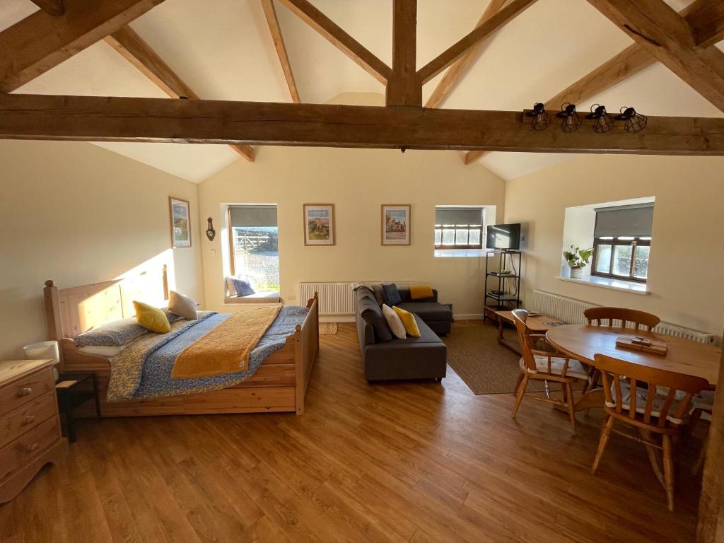a bedroom with a bed and a living room at The Barn Studio in Millers Dale