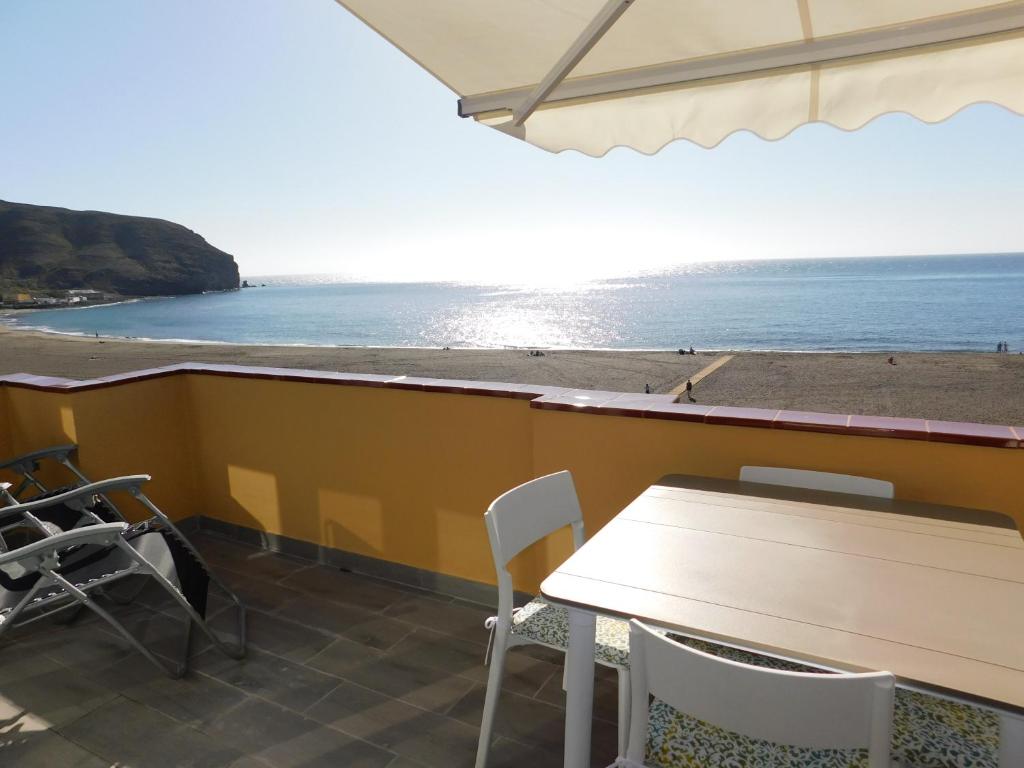 a table and chairs with a view of the beach at PERLA Penthouse in Gran Tarajal