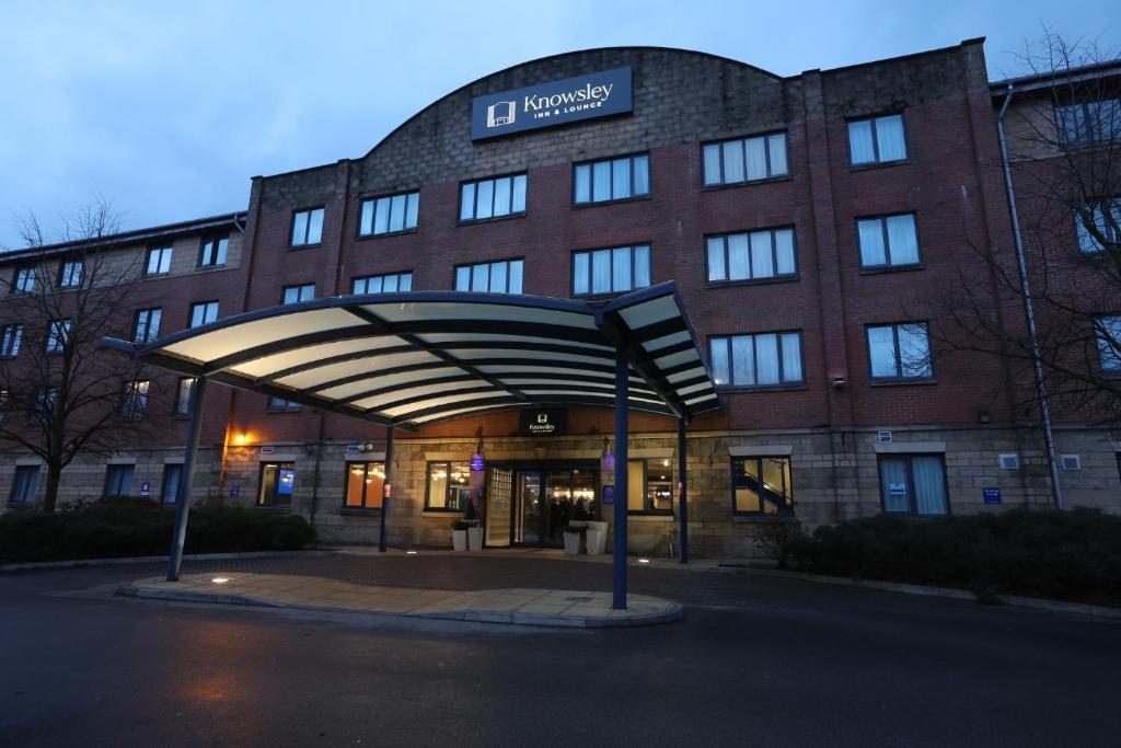 un grande edificio in mattoni con un cartello di fronte di Knowsley Inn & Lounge formally Holiday Inn Express a Knowsley