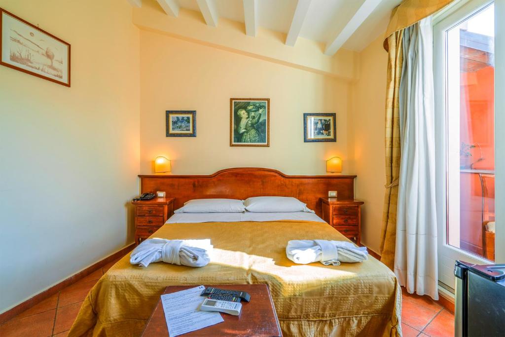 Hotel Mediterraneo في سيراكوزا: غرفة نوم عليها سرير وفوط