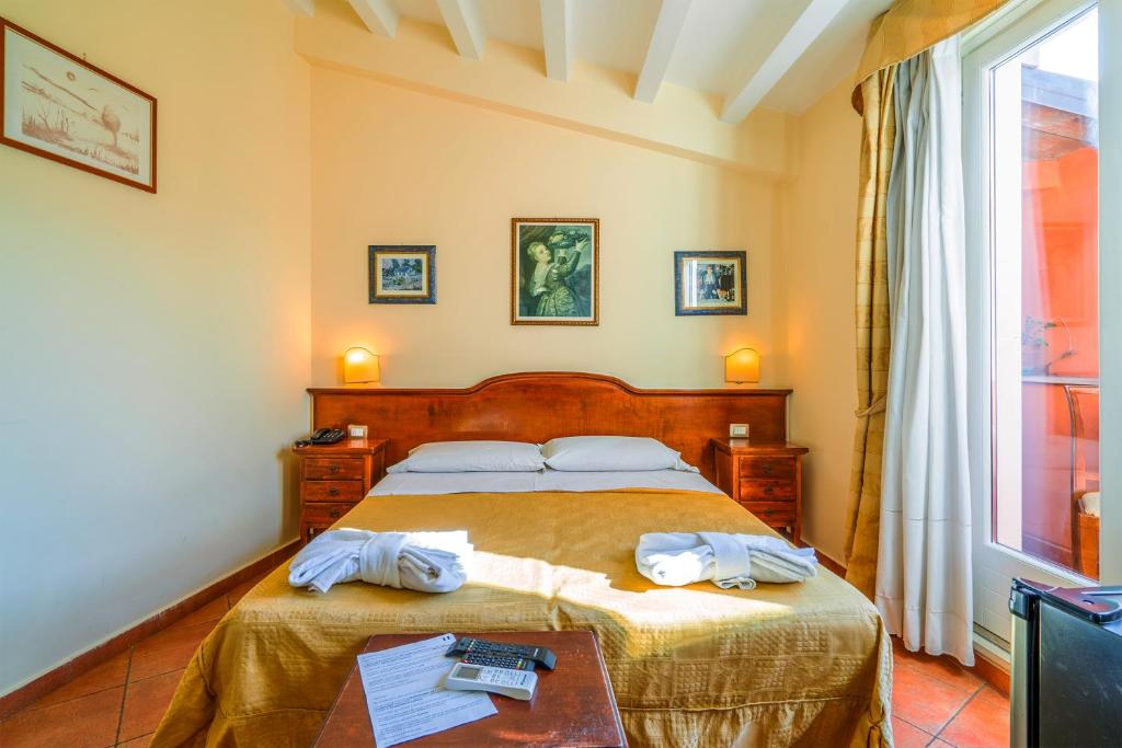 a bedroom with a bed with two towels on it at Hotel Mediterraneo in Syracuse