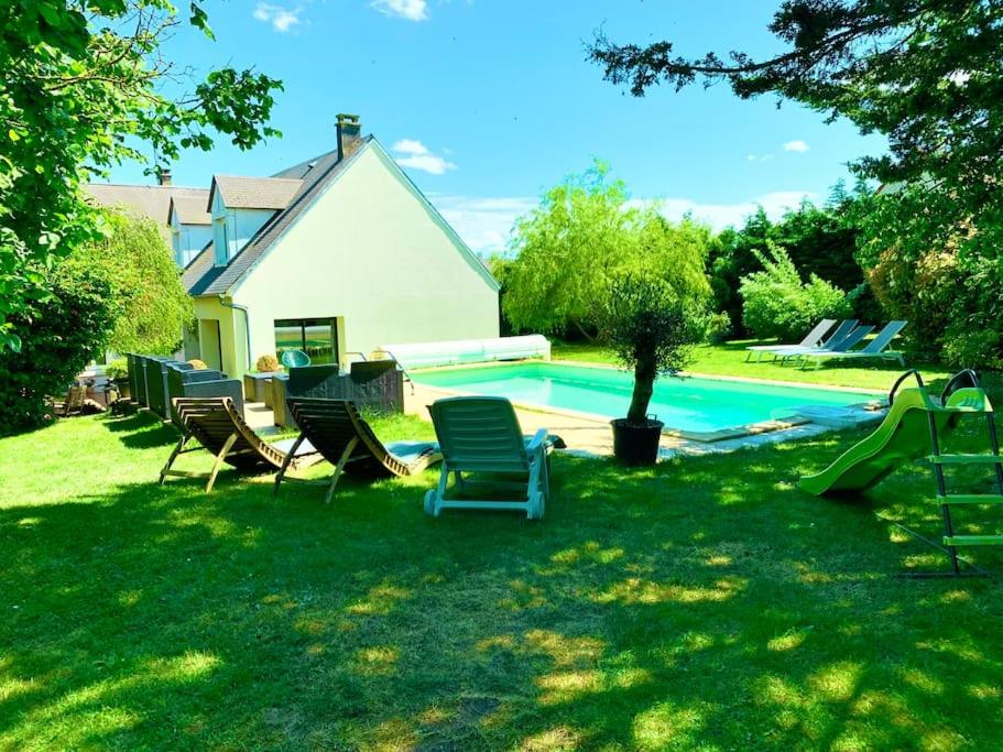 a yard with chairs and a swimming pool at Maison piscine famille nombreuse 13 couchages in Écublé