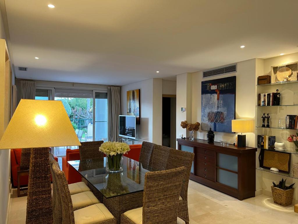 a dining room and living room with a table and chairs at ALCAZABA beach in Estepona