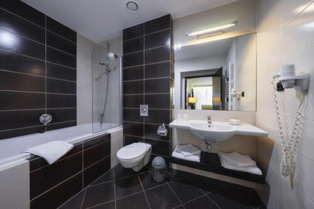 a bathroom with a sink and a toilet at Hotel Astory Plzeň in Plzeň