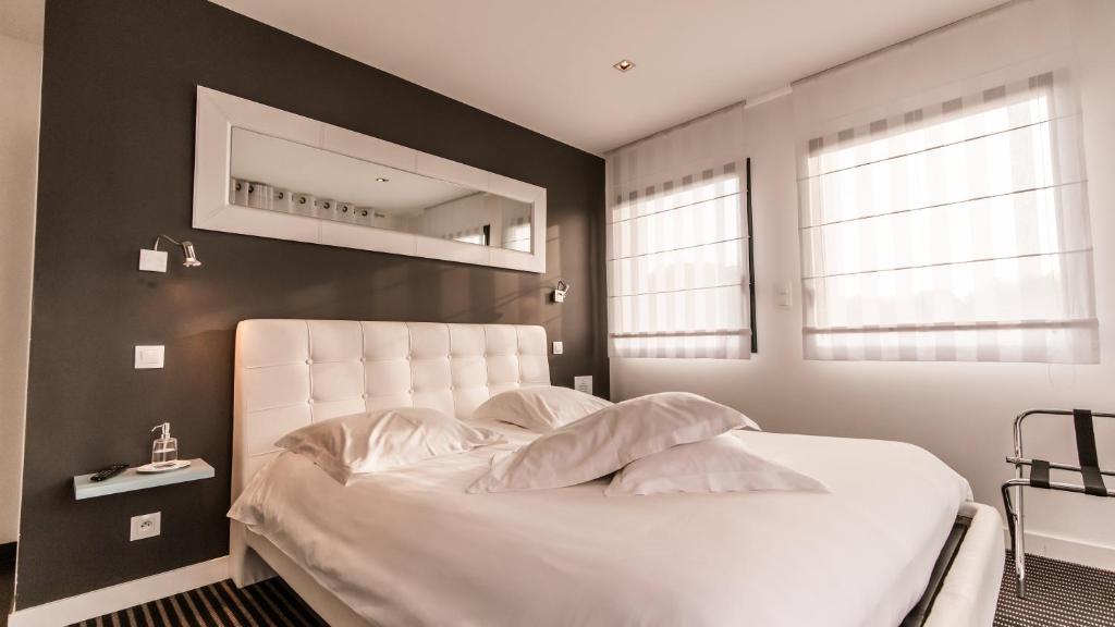 a bedroom with a white bed with a black wall at Chambres d'Hôtes de l'Avel Vor in Port-Louis