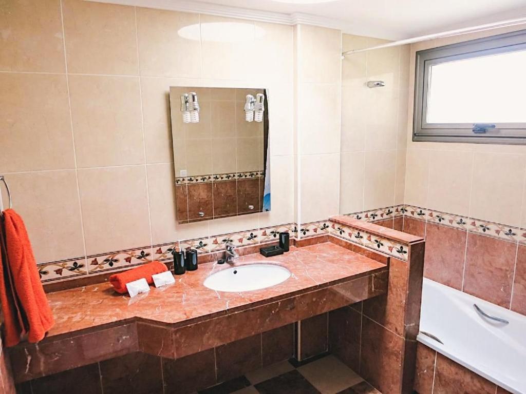 uma casa de banho com um lavatório, uma banheira e um espelho. em Bungalow with 2 bedrooms, Playa la Tejita em El Médano