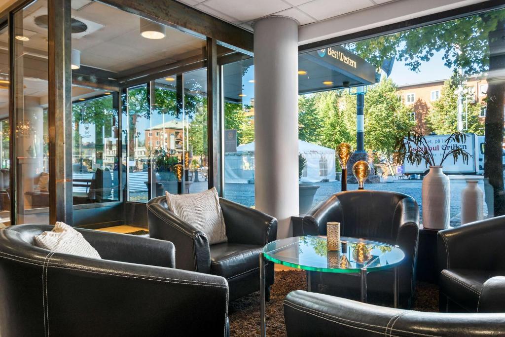 a lobby with leather chairs and a table at Best Western Malmia Hotel in Skellefteå