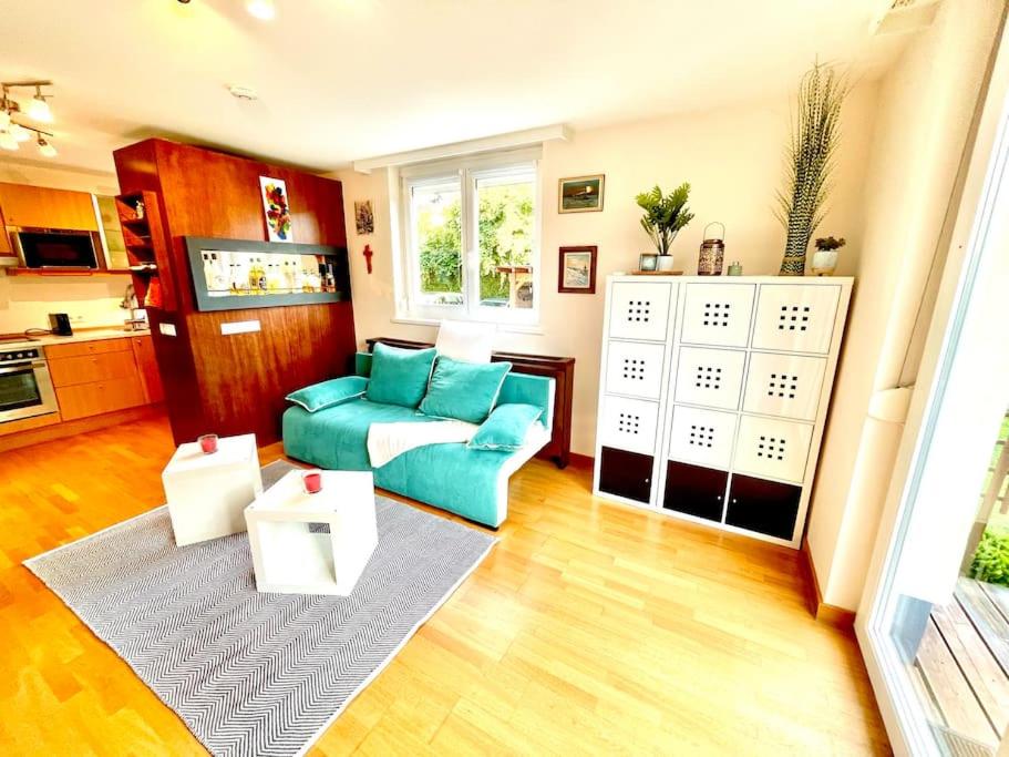 a living room with a blue couch and a kitchen at Schöne Wohnung mit eigenen Eingang und Terrasse in Gösseling