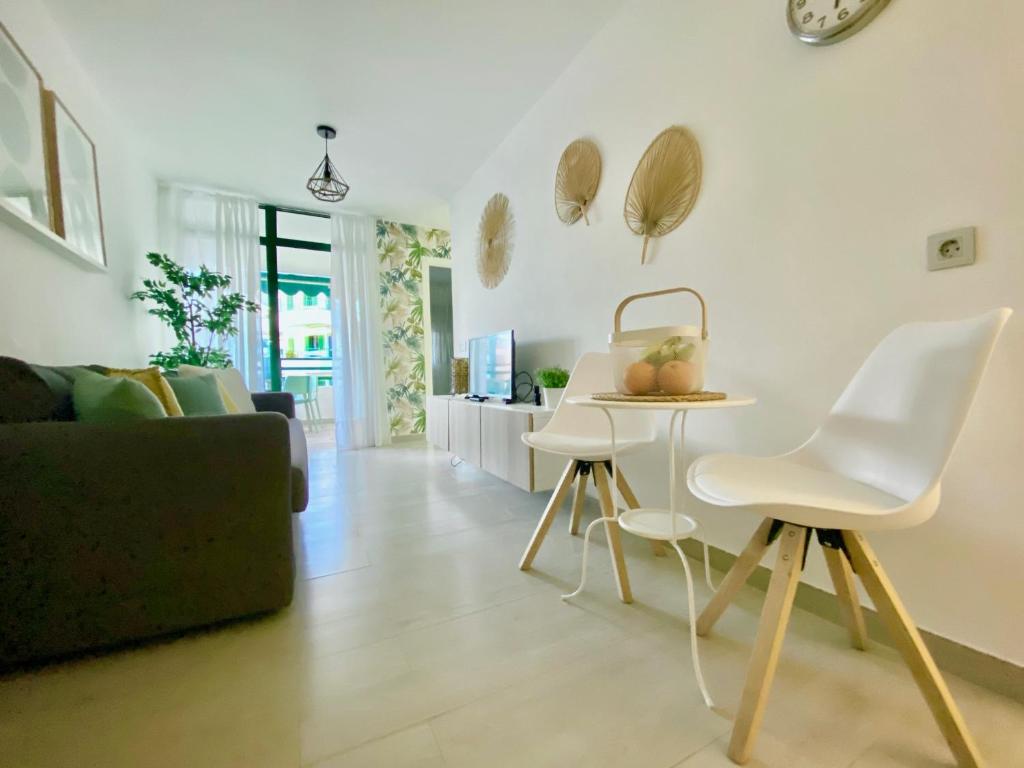 een woonkamer met een bank en een tafel en stoelen bij Apartamento Las Olas • Playa del Inglés in Playa del Inglés