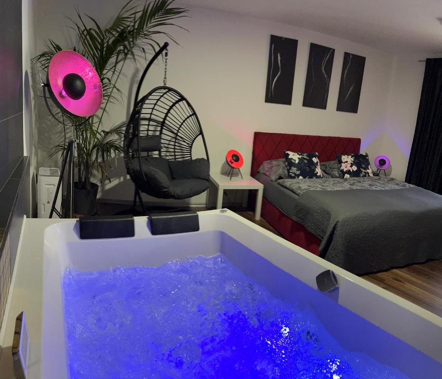 a room with a tub filled with purple water at FiftyShades Apartmán s vířivkou in Jihlava