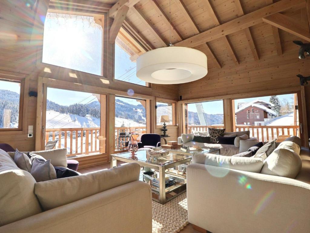 a living room with couches and a table and windows at Chalet Les Gets, 7 pièces, 12 personnes - FR-1-627-6 in Les Gets