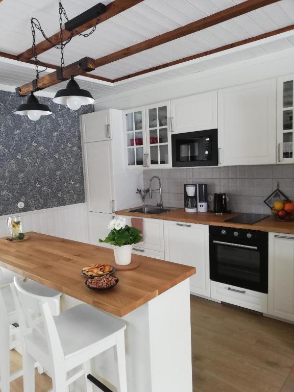 a kitchen with white cabinets and a wooden counter top at Kaptenite Kodu in Kuri