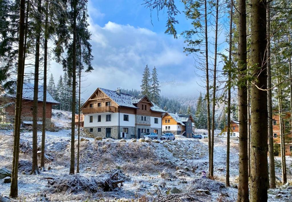 una casa en el bosque con nieve en el suelo en Apartmány Kellov Dom, en Demänovská Dolina