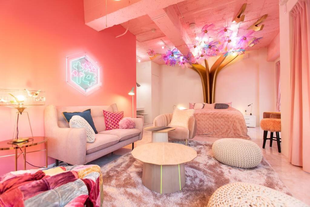 uma sala de estar com um sofá e uma mesa em Moshi Moshi Rooms em Tóquio