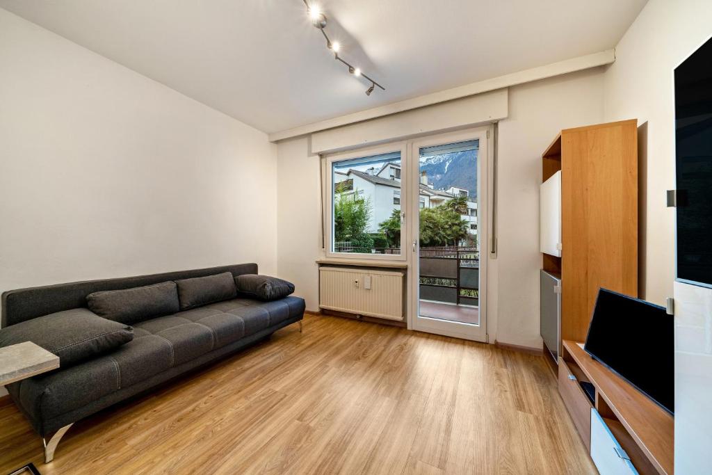 a living room with a couch and a large window at Appartement Franziskus in Merano