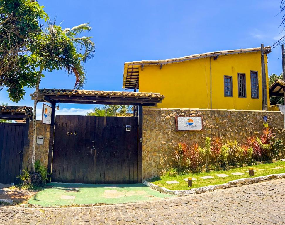 una casa con una puerta negra y un edificio amarillo en Abal Pousada, en Búzios