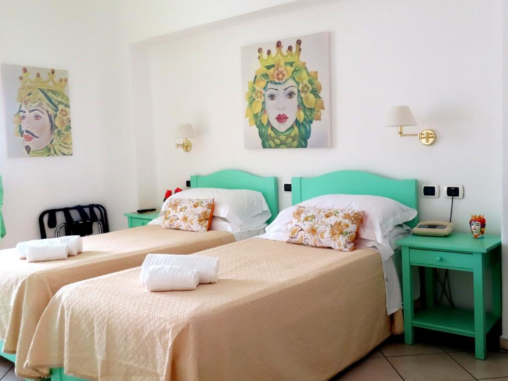Stromboli Trekking Accommodation - Room and Excursion for 2 included في سترومبولي: سريرين يجلسون بجانب بعض في غرفة