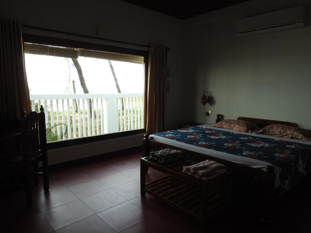 Postel nebo postele na pokoji v ubytování Alleppey Beach Garden