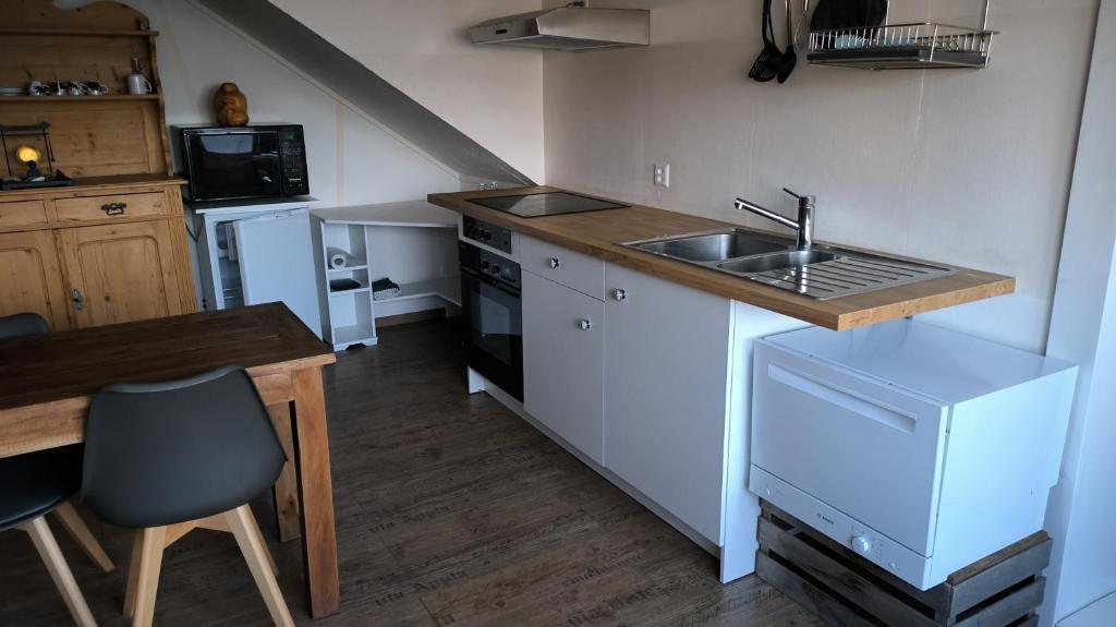 eine Küche mit einer Spüle und einer Arbeitsplatte in der Unterkunft Mini Happy home in Reconvilier