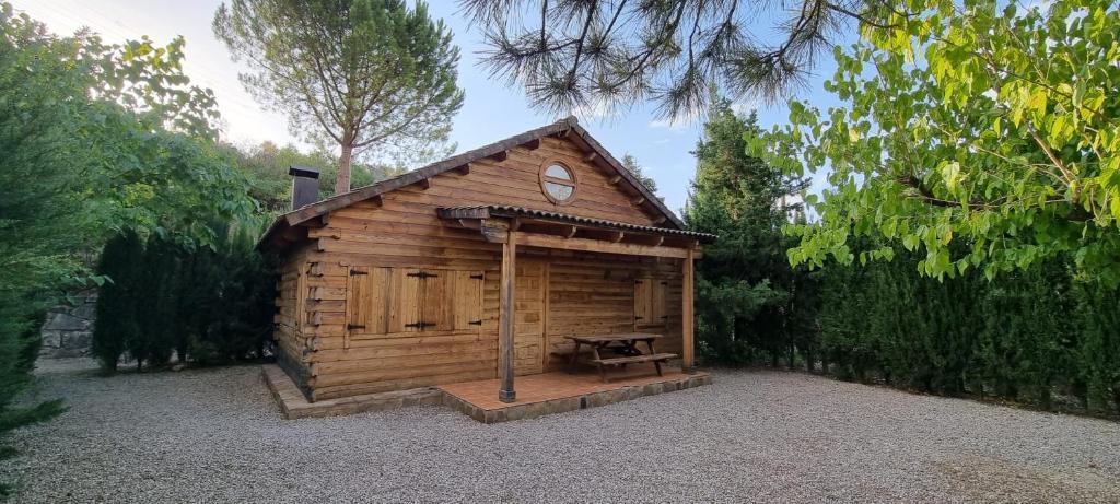 a wooden cabin with a bench in front of it at CASA DE MADERA ZUMACAR III in Cazorla