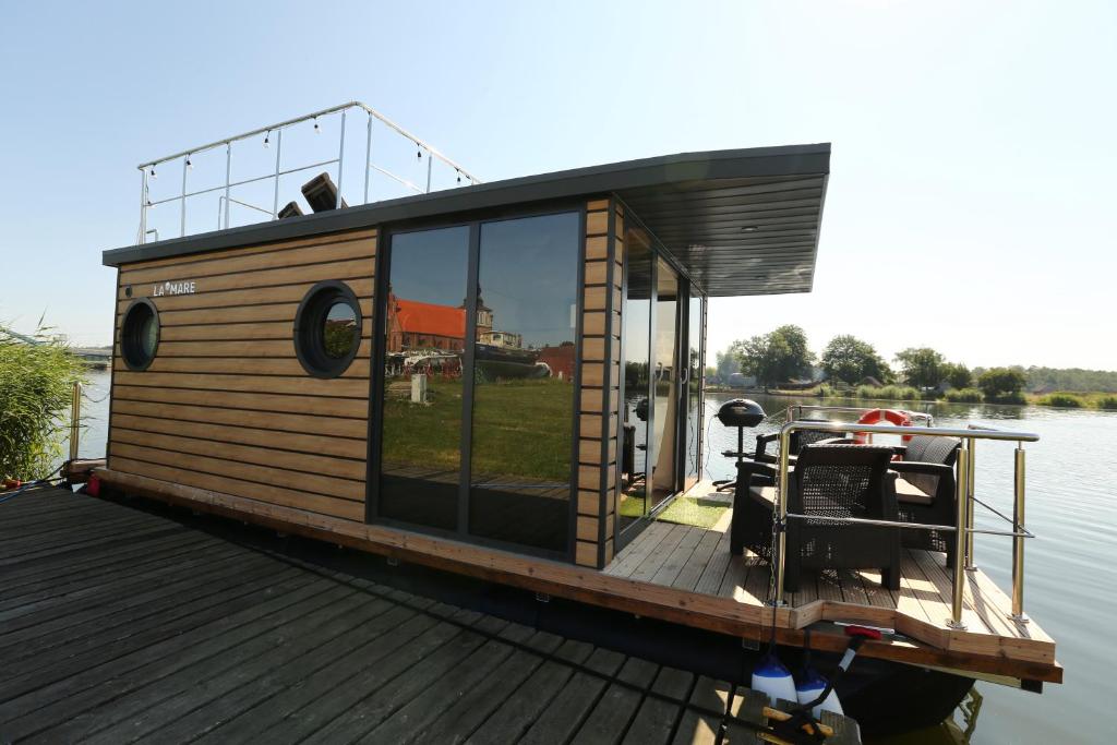 a small house on a boat on the water at Houseboat in Wolin