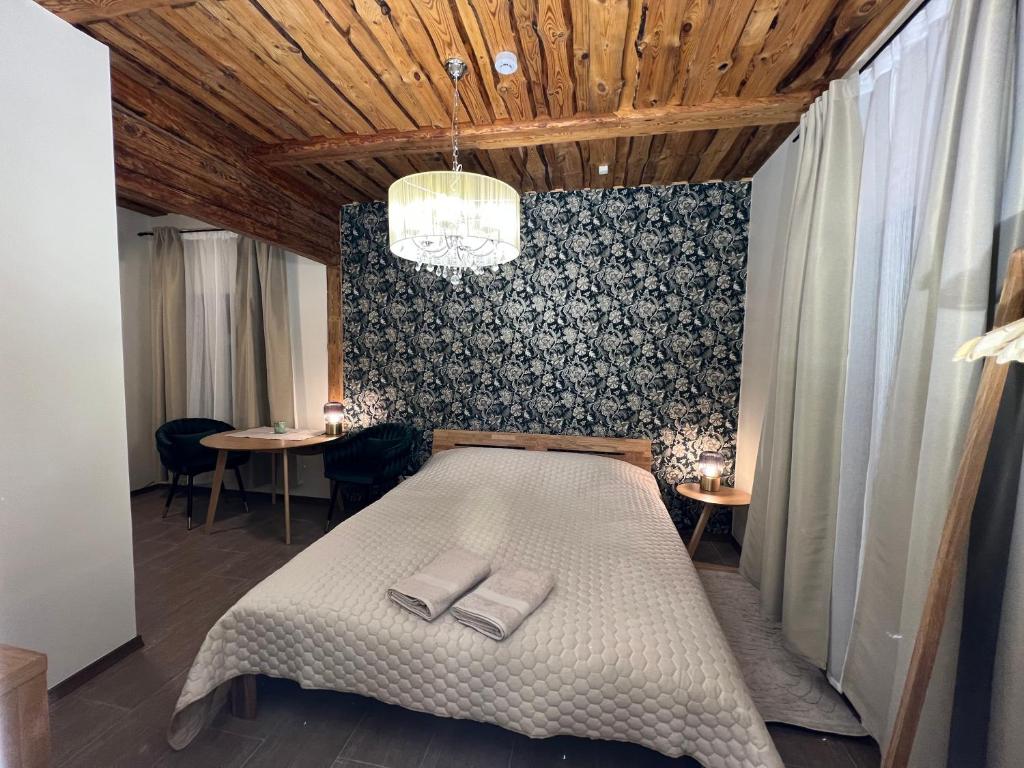 1 dormitorio con 1 cama grande y techo de madera en Karlova Manor Apartments, en Tartu