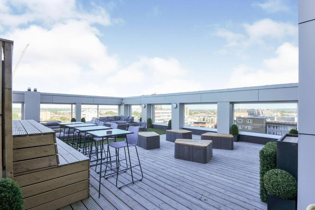 a rooftop deck with tables and chairs on a building at Modern 1 bedroom apartment in the center of Croydon in Croydon