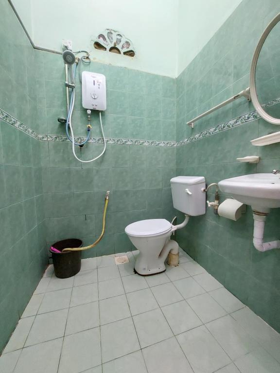 y baño con aseo y lavamanos. en Rumah Rehat QNM Holidays en Kuala Terengganu