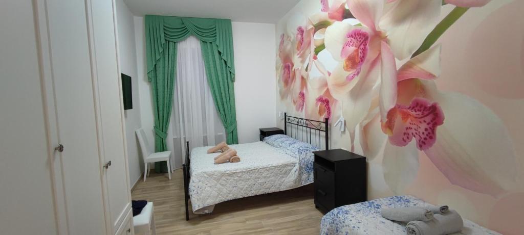 1 dormitorio con 2 camas y flores rosas en la pared en Maria in Vaticano, en Roma