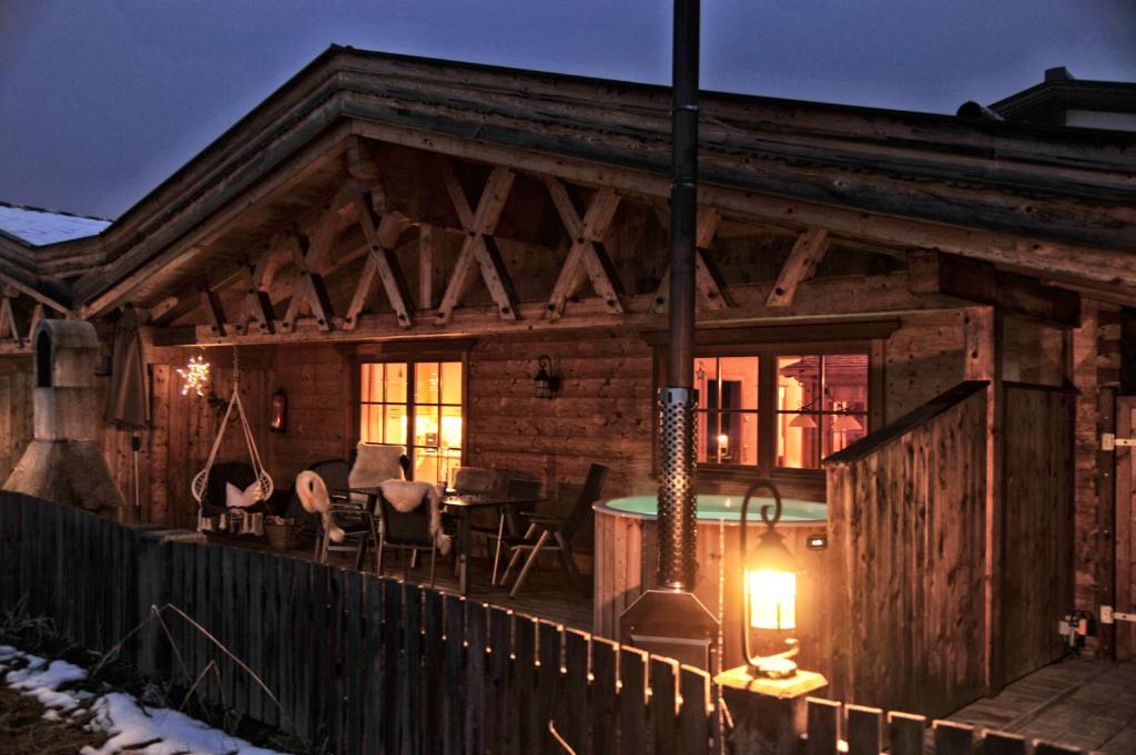 a wooden house with a table and chairs on a deck at Luxury Chalets Wiesenruh in Bichlbach