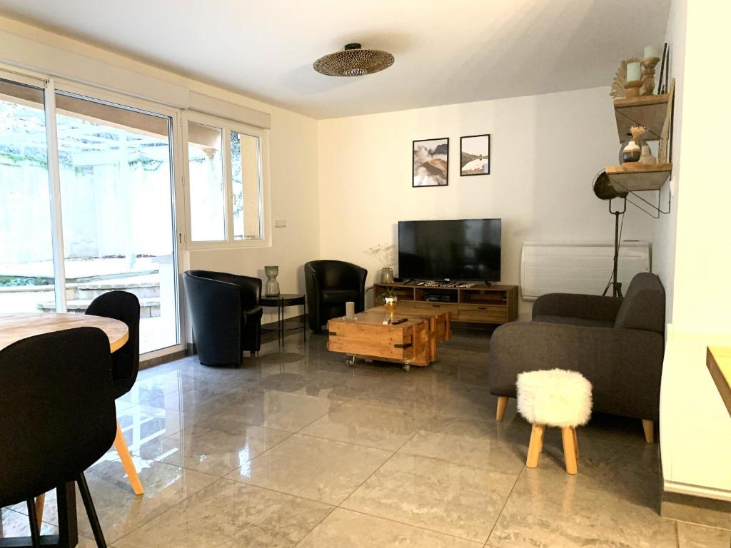 a living room with a couch and a tv at Appartement tout confort avec terrasse in Reims