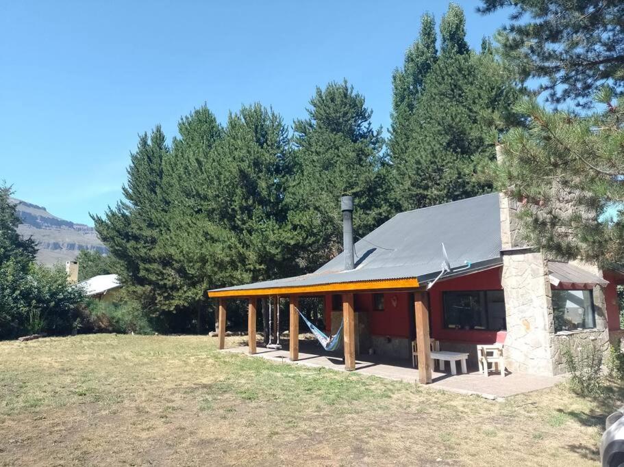 un pequeño edificio rojo con techo negro en Cabaña Quela en San Martín de los Andes