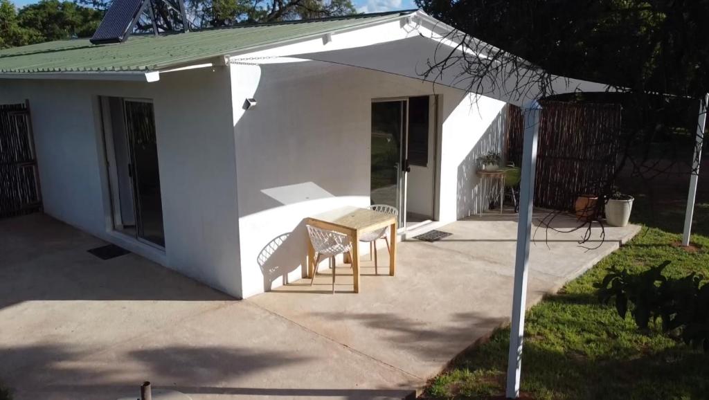 Casa blanca con 2 sillas y mesa en Pan's Breeze Overnight Accommodation en Dalmada AH