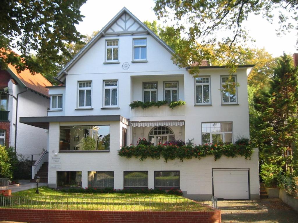 una casa blanca con muchas ventanas en Pension Thiel, en Bad Schwartau