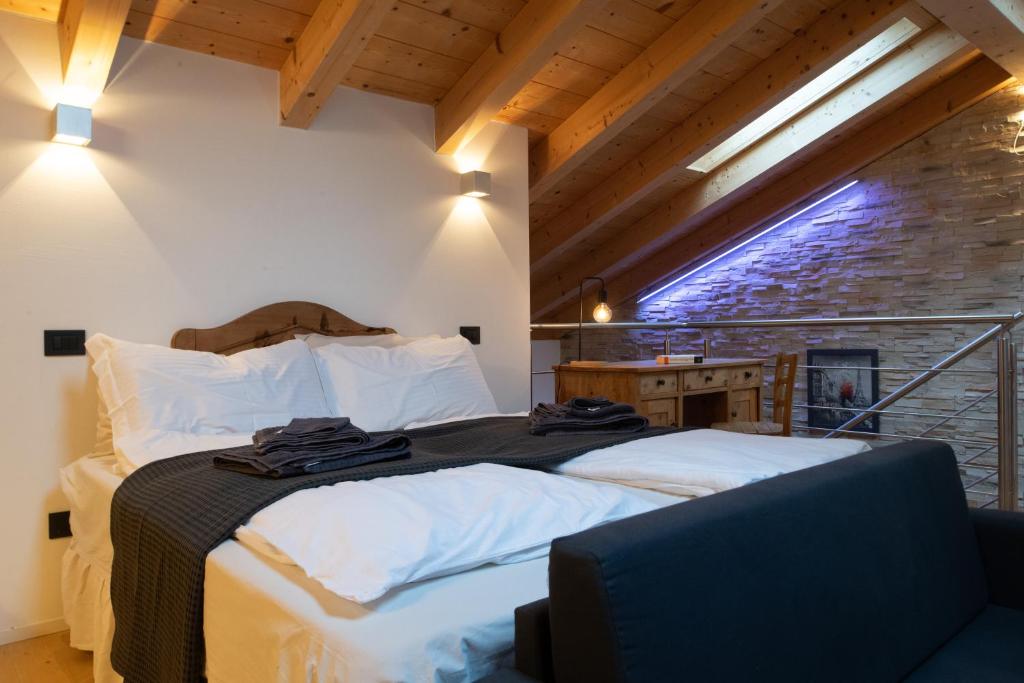 sypialnia z łóżkiem z białą pościelą i oknem w obiekcie Relax in Pineta w mieście Caldonazzo