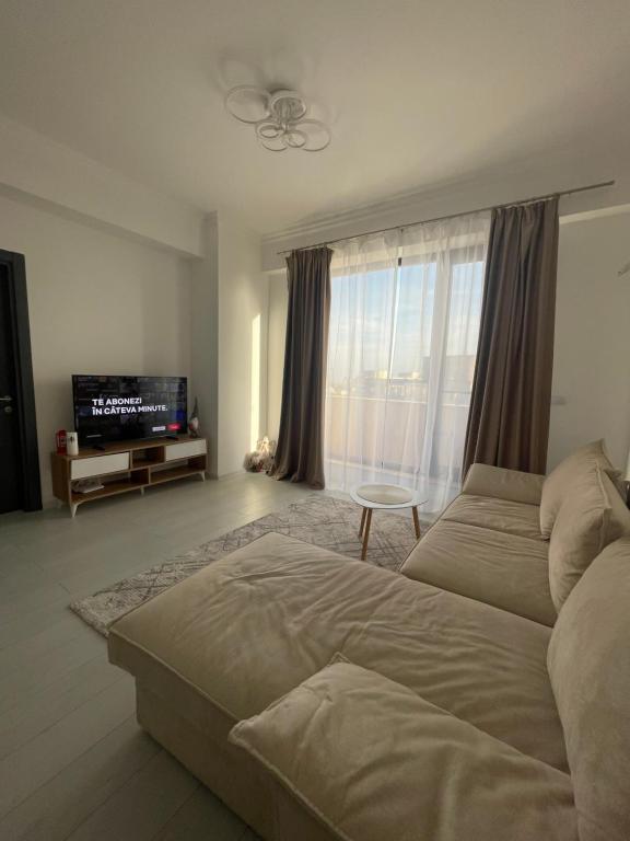 Sala de estar con cama y TV en City View Apartment, en Constanţa