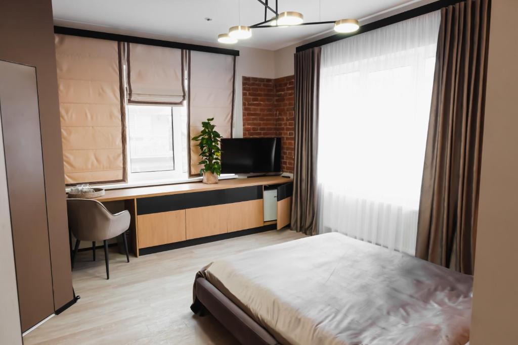 a bedroom with a bed and a desk and a television at Miracle Place in Ivano-Frankivsʼk