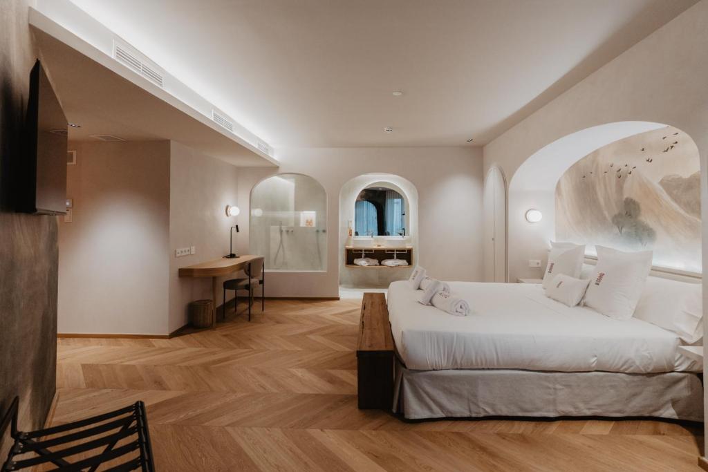 Schlafzimmer mit einem großen weißen Bett und einem Schreibtisch in der Unterkunft Hotel Petit Luxe in Terrassa