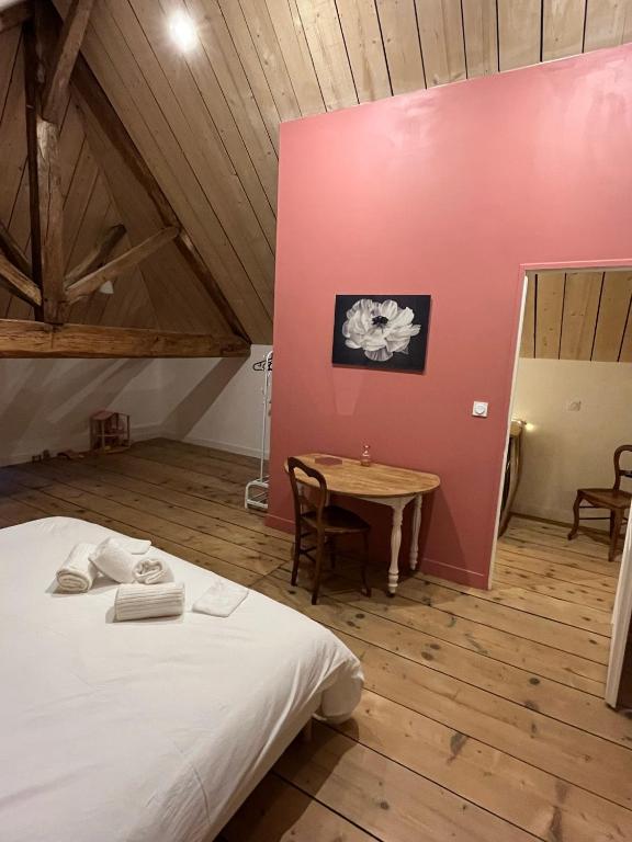 a bedroom with a white bed and a table at Gite du Prieuré in Chagny