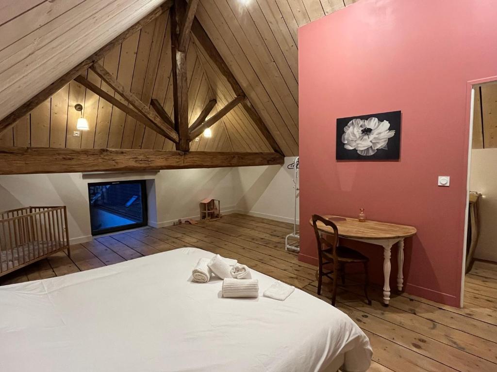 a bedroom with a large bed and a table at Gite du Prieuré in Chagny