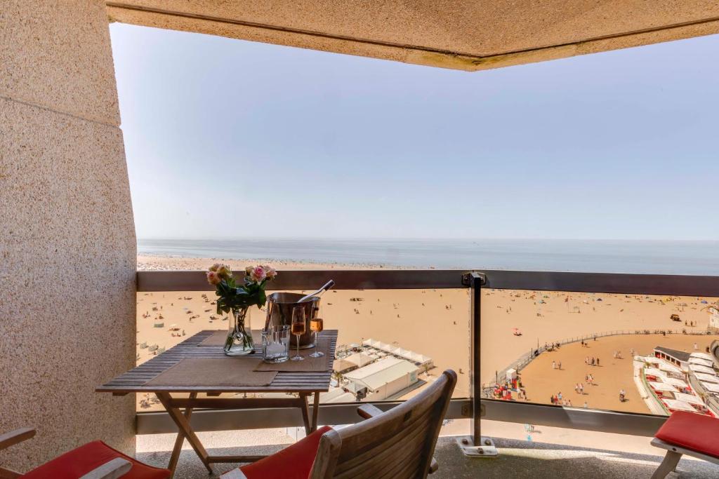 a balcony with a table and a view of a beach at Luxury Suite with Seaview in Ostend