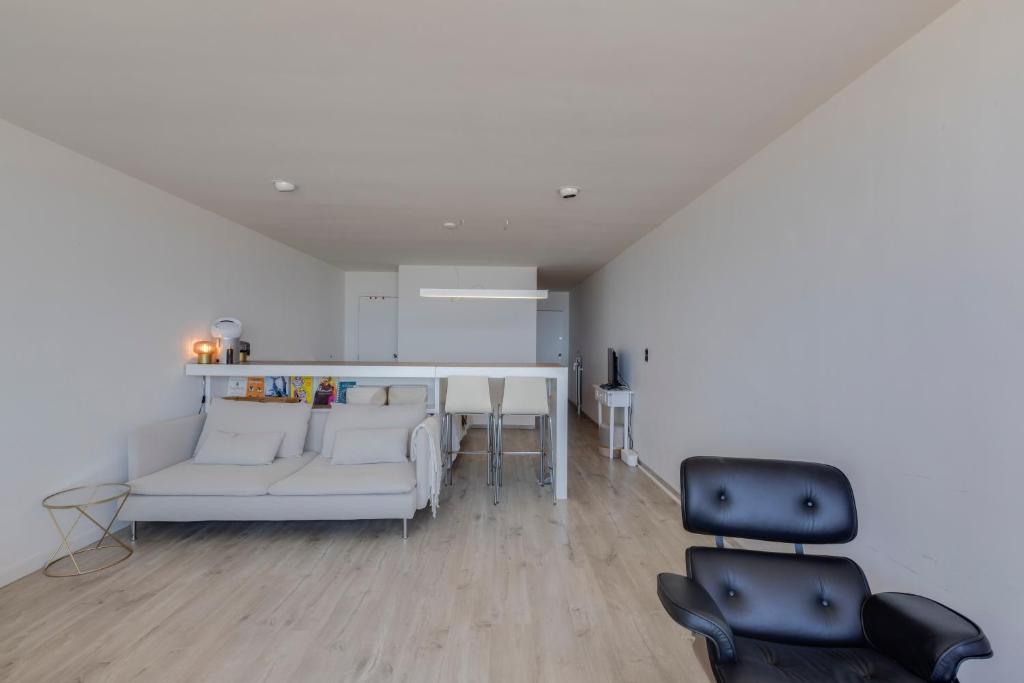 a living room with a white couch and two chairs at Luxury Suite with Seaview in Ostend