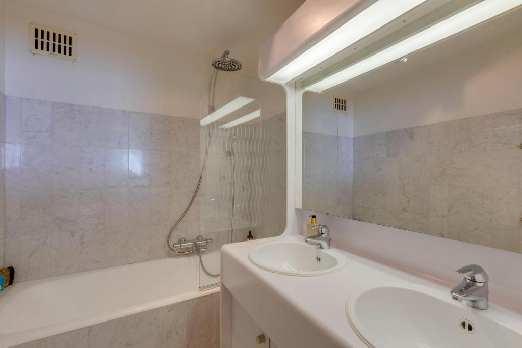 a bathroom with a sink and a tub and a mirror at Luxury Suite with Seaview in Ostend